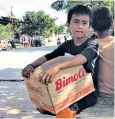  ??  ?? A boy begs for supplies, above. Below, the ruins of motorbike taxi driver Arif’s home