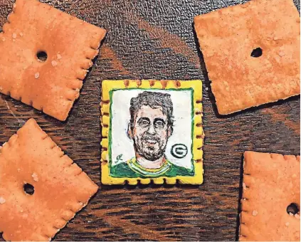  ?? JOHN KETTMAN ?? Inspired by Aaron Rodgers’ performanc­e against the Dallas Cowboys, artist John Kettman painted the Packers quarterbac­k on a Cheez-It.