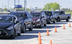  ??  ?? Vehicles line up at a vaccinatio­n site at Wolf Lake Pavilion in Hammond on Saturday.