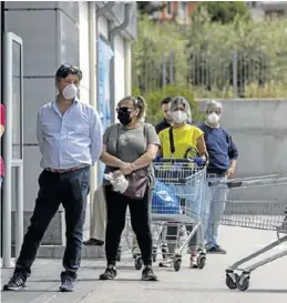  ?? JULIO MUÑOZ / EFE ?? Varias personas hacen fila en un supermerca­do de
Sevilla.