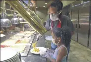  ??  ?? Whitney Duncan helps her daughter Adalynn Duncan, 7, of Reading get food at the buffet.