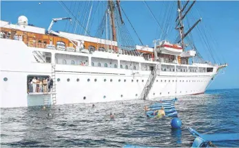  ?? FOTOS ( 4): DPA ?? Schwimmen neben dem Segelschif­f, wie hier bei Sea Cloud Cruises: Die Kreuzfahrt ist immer noch eine beliebte Form der Luxusreise, auch wenn das Segment zunehmend zu einem Massenmark­t geworden ist.