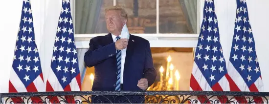  ?? WIN MCNAMEE/ GETTY IMAGES ?? After being treated for COVID- 19 at Walter Reed National Military Medical Center, President Donald Trump takes off his mask upon his return to the White House.