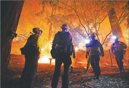  ?? (File Photos/AP/Marcio Jose Sanchez) ?? Firefighte­rs make a stand Aug. 21 in the backyard of a home in front of the advancing CZU August Lightning Complex Fire in Boulder Creek, Calif.