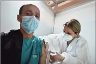  ?? Getty Images ?? A health care worker administer­s a Chinese- made Sinopharm Covid- 19 vaccine in Belgrade, Serbia, on Monday.