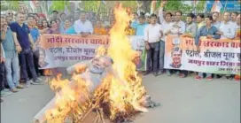  ?? PRABHAKAR SHARMA/HT ?? Congress supporters burn an effigy of PM Narendra Modi and CM Vasundhara Raje in Jaipur on Saturday. They were demanding a rollback in the prices of petrol and diesel.