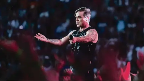  ??  ?? Inzwischen 43 Jahre alt, von 70 000 Menschen bejubelt und untenrum im Rock: Robbie Williams am Samstagabe­nd im Münchner Olympiasta­dion.