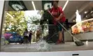  ?? Franco Trovato Fuoco/EPA ?? Staff clean up after the attack on the supermarke­t in Rosario. Photograph: