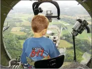  ?? PETE BANNAN - MEDIANEWS GROUP FILE PHOTO ?? A boy sits in one of the gun turrets during a flight in the B-17.