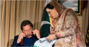  ?? AP ?? Pakistan government spokespers­on Firdous Ashiq Awan consults with Pakistani Prime Minister Imran Khan in his office in Islamabad.