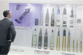  ?? PHOTOS BY REUTERS ?? LEFTA visitor looks at ammunition­s on display at Egypt Defence Expo (EDEX 2018) in Cairo on Monday. FAR LEFT Models of helicopter­s are displayed at the Russian stand.