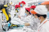  ?? REUTERS • FILE ?? Labourers work at an assembly line to produce ventilator­s in response to the spread of COVID-19 at Vsmart factory of Vingroup outside Hanoi, Vietnam in this Aug. 3 photo.
