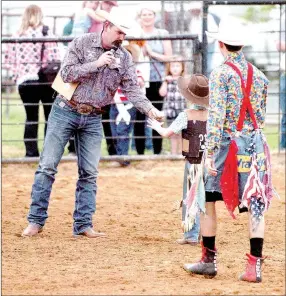  ?? MARK HUMPHREY ENTERPRISE-LEADER ?? Wyatt Lundberg collects $30 cash as the payoff for winning the May 17, 2017, go-around in Mutton Bustin’ from Brandon Wren, (left), announcer for the 64th annual Lincoln Rodeo in 2017. The American Cowboys Rodeo Associatio­n honored Wren as Announcer-of-the-Year for 2014. The 2018 Lincoln Rodeo is co-sanctioned by the ACRA and IPRA.