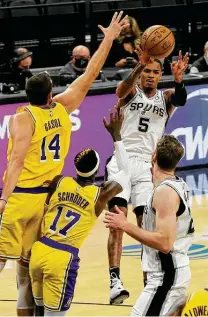  ?? Kin Man Hui / Staff photograph­er ?? Dejounte Murray, who led the Spurs with a career-high 29 points, passes against the Lakers’ Marc Gasol (14) and Dennis Schroder (17) to Jacob Poeltl down low on Wednesday.