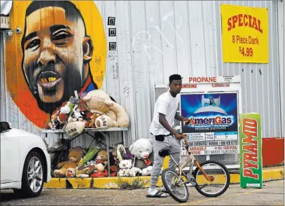  ?? Gerald Herbert ?? The Associated Press A memorial and mural mark the food mart in Baton Rouge where Alton Sterling, 37, was shot and killed by police a year ago.