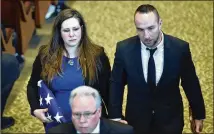  ??  ?? Alex Maddox, widow of slain officer Chase Maddox, and her brother, Coleton Segars, hold hands as they leave Glen Haven Baptist Church in McDonough on Saturday. Alex Maddox and her two boys were seated in the front row at the funeral with other family...