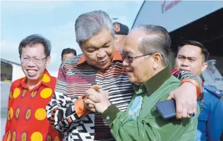  ?? BERNAMAPIX ?? Ahmad Zahid speaks to Sarawak Deputy Chief Minister Datuk Amar Douglas Uggah Embas at the Kuching Internatio­nal Airport after attending a briefing on the rabies outbreak in the Serian district. At left is Sarawak Local Government and Housing Minister...