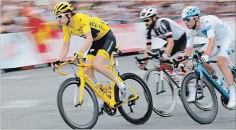  ?? LAURENT CIPRIANI THE ASSOCIATED PRESS ?? Tour de France winner Britain’s Geraint Thomas, wearing the overall leader’s yellow jersey, Germany’s Simon Geschke and France’s Pierre Roger Latour, right, ride during the 21st stage of the Tour de France on Sunday.