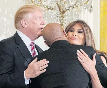  ?? AFP ?? US First Lady Melania Trump hugs US Surgeon General Jerome Adams as US President Donald Trump applauds after he spoke at a National African American History Month reception in the White House on Tuesday in Washington, DC.