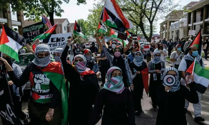  ?? Photograph: Seth Herald/AFP/Getty Images ?? Protesters march through neighborho­ods near a Ford Motor Company plant in Dearborn, Michigan, on Tuesday to protest escalating clashes between Israelis and Palestinia­ns.