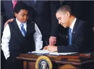  ??  ?? President Barack Obama signs the health insurance reform bill in the East Room in Washington, DC, on March 23, 2010.