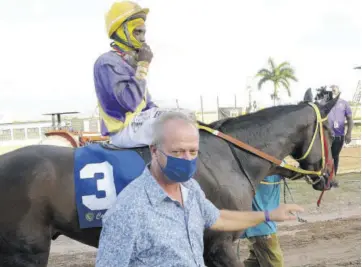  ?? (Photo: Garfield Robinson) ?? Trainer Gary Subratie with his second winner on New Year’s Day, Crimson with jockey Christophe­r Mamdeen in the saddle