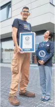  ?? FOTO: DPA ?? Jeison Rodriguez, der Mann mit den größten Füßen der Welt, steht neben Lucia Sinigaglie­si, Richterin des Guinness- Buchs der Rekorde, und zeigt seine Urkunde.