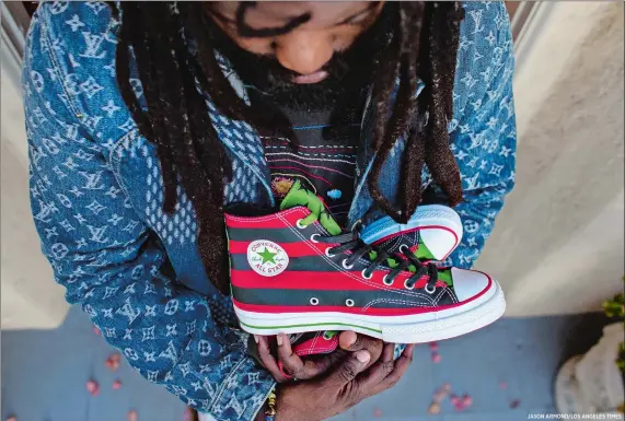  ?? JASON ARMOND/LOS ANGELES TIMES ?? Tremaine Emory, above, with the sneakers he designed, inspired by the Pan-African flag. He says the sneaker, a collaborat­ion with Converse, will drop in October and that marketing for the shoe will encourage voting in the November election.