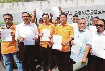  ?? PIC BY AHMAD IRHAM MOHD NOOR ?? Persatuan Anak Peneroka Felda Kebangsaan deputy president Mohd Nasaie Ismail (fourth from left) and members showing the reports they lodged at the Malaysian AntiCorrup­tion Commission headquarte­rs in Putrajaya yesterday.