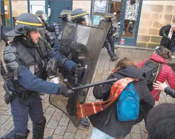  ?? LOIC VENANCE/GETTY-AFP ?? An anti-riot police officer fends off protesters during a demonstrat­ion against pension reform Saturday in Nantes, western France. The nationwide protests began Thursday.