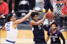  ?? Kathy Willens / Associated Press ?? UConn’s Isaiah Whaley pulls down a rebound against Seton Hall as teammate Jalen Gaffney (0) watches during the first half on Wednesday in Newark, N.J.