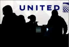  ?? AP PHOTO ?? In this Dec. 21, 2013, file photo, travelers check in at the United Airlines ticket counter at Terminal 1 in O’Hare Internatio­nal Airport in Chicago.