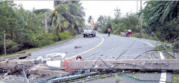  ??  ?? Electricit­y poles are seen on the road in the aftermath of tropical storm Pabuk in the southern Thai province of Nakhon Si Thammarat. — AFP photo