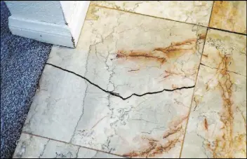  ??  ?? The cracks in the tile are seen Thursday at Alexander and Elena Wilding’s home.