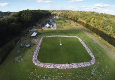  ?? Aerial photo by Joseph B. Nadeau ?? The Athena’s Cup world record chain of bras is seen stretched out across the field at River’s Edge Recreation­al Complex on Tuesday. By the end of counting Tuesday evening, the volunteers had linked and measured 195,599 bras, according to organizers.