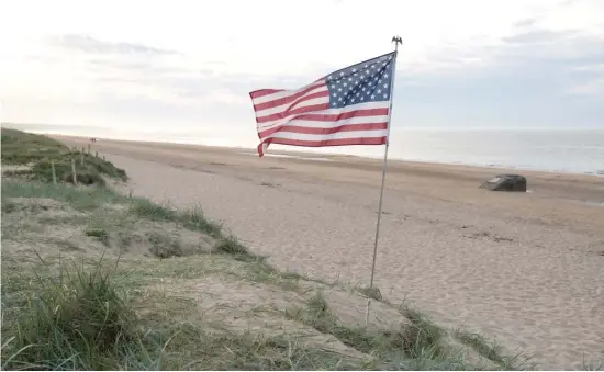  ?? SEAN GALLUP/GETTY IMAGES ?? An American flag flies at Omaha Beach on Sunday near Colleville-sur-Mer, France. June 6 marks the 75th anniversar­y of the D-Day invasion.