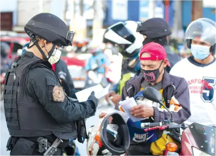  ?? PHOTO BY JOHN ORVEN VERDOTE ?? The Philippine National Police-Highway Patrol Group and SWAT randomly inspect motorcycle riders in Caloocan City on Oct. 23, 2020 amid reports of crimes committed by persons ‘riding-in-tandem’. The PNP reported, however, a 57-percent drop in motorcycle-related crimes during the Covid-19 pandemic.