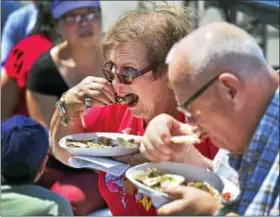  ?? PETER HVIZDAK / HEARST CONNECTICU­T MEDIA ?? Milford, Connecticu­t: Saturday. Jacqueline Swanson and her husband Roger, of Southingto­n eat oysters together Saturday afternoon during their first visit to the Milford Oyster Festival in Milford. For a slideshow, visit PHOTOS.NEWHAVENRE­GISTER.COM