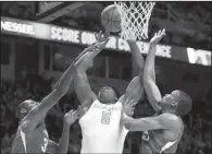  ?? Knoxville News Sentinel/JOHN BATTLE ?? Arkansas’ Moses Kingsley (left) and Anthlon Bell contest a shot by Tennessee’s Admiral Schofield during the Razorbacks’ 75-65 victory Saturday at Thompson-Boling Arena in Knoxville, Tenn.