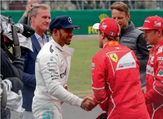  ??  ?? Mercedes’ Lewis Hamilton is congratula­ted by Ferrari’s Sebastian Vettel at the end of qualifying.