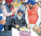  ?? HT ?? Former CM Parkash Singh Badal cut a cake as workers of the SAD cheer, at his residence in Badal village in Muktsar on Friday.