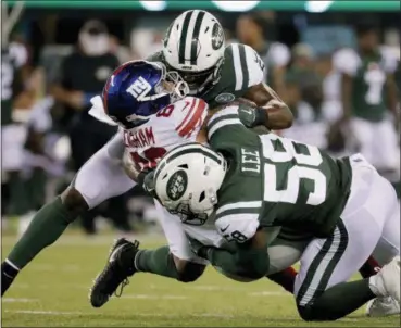  ?? JULIO CORTEZ — ASSOCIATED PRESS ?? Jets linebacker­s Avery Williamson, top, and Darron Lee tackle Giants tight end Evan Engram during the Giants’ 22-16 win in East Rutherford, N.J., on Friday night.