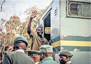  ??  ?? A supporter of the opposition MDC Alliance gestures while being escorted to a prison truck from a magistrate­s’ court in Harare. Mr Mnangagwa celebrates his election victory, left