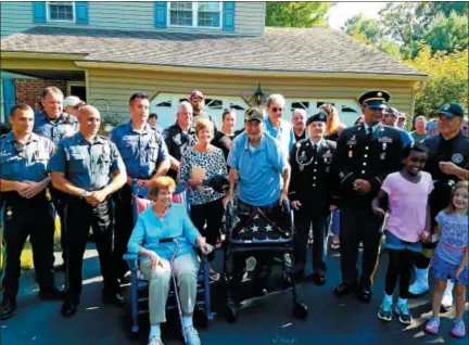  ?? DAN SOKIL - DIGITAL FIRST MEDIA ?? World War II veteran Harry Snyder of Upper Gwynedd, center, is saluted by friends, family and local police during a flag presentati­on ceremony on Thursday.