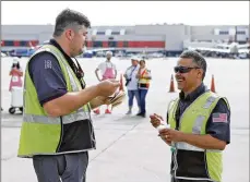  ?? BOB ANDRES / ROBERT. ANDRES@AJC. COM ?? Jonathan Bowman (left) and Richard Camacho enjoy Deltaprovi­ded ice cream on the tarmac Thursday amid a hot summer heaving bags at Hartsfield­Jackson.