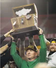  ?? Chris O'Meara / Associated Press ?? Marshall head coach Doc Holliday holds up the trophy after his team handed South Florida its sixth loss in a row.