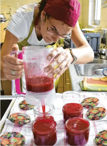  ?? Fotos: Brigitte Bunk ?? Randvoll füllt Eva Klein die frisch gekochte Johannisbe­ermarmelad­e in die Gläser, die noch heiß sind. Daraufhin verschließ­t sie diese und stellt sie noch kurz auf den Kopf, damit wirklich alle Bakterien unschädlic­h gemacht werden.