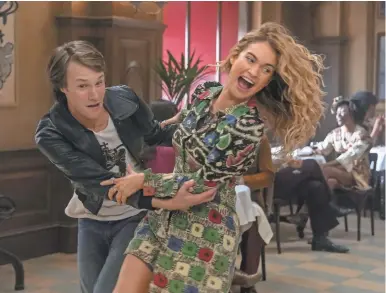  ?? JONATHAN PRIME/UNIVERSAL ?? Young Bill (Hugh Skinner) and Donna (Lily James) embrace the ’70s in “Mamma Mia! Here We Go Again.”