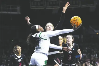  ?? MICHAEL CATERINA/AP ?? NOTRE DAME’S KK BRANSFORD (center left) drives as Southern Utah’s Lizzy Williamson (center right) defends during the second half of a first-round game in the NCAA Tournament on Friday in South Bend, Ind.