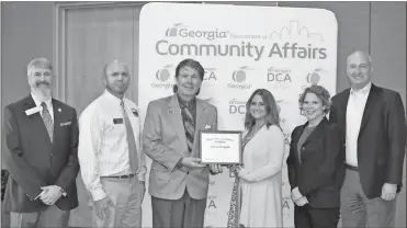  ?? Contribute­d ?? Ringgold City Council member Randall Franks (center) accepts the certificat­e designatin­g the city as a rural zone.